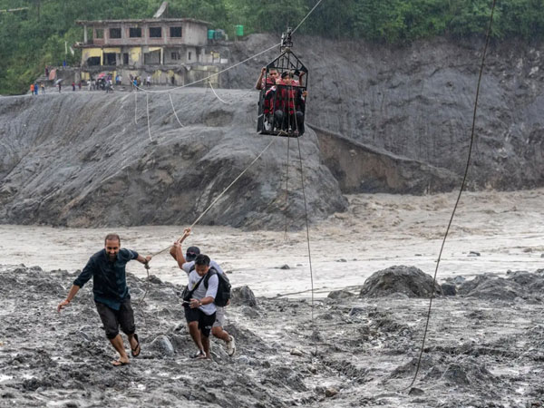 Trading food for medicine and crossing the river by zip line are part of life in Nepal flood zone
